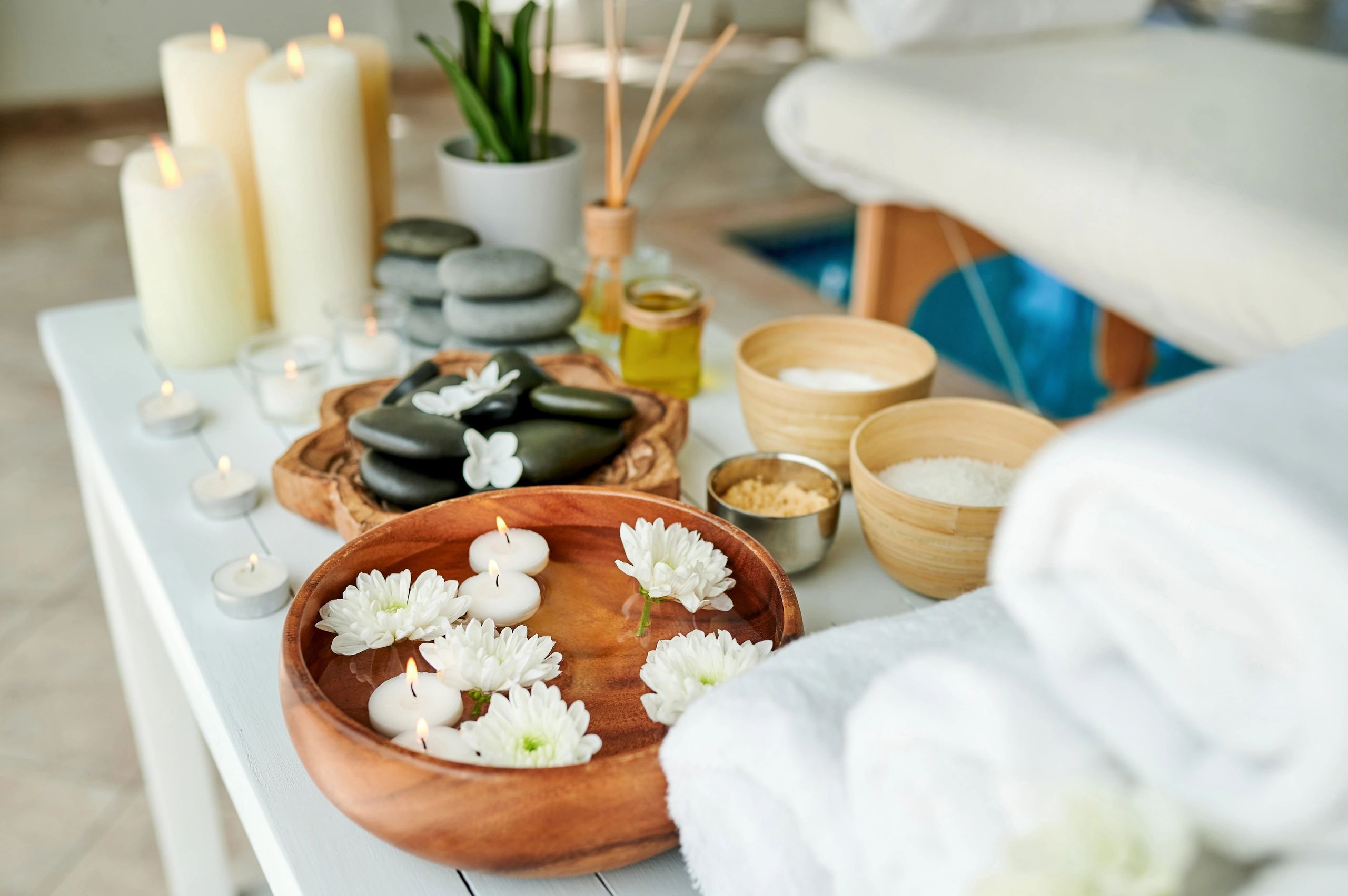 Shot of hot stones, towels, rough salt and a bowl of water on a table in an empty spa